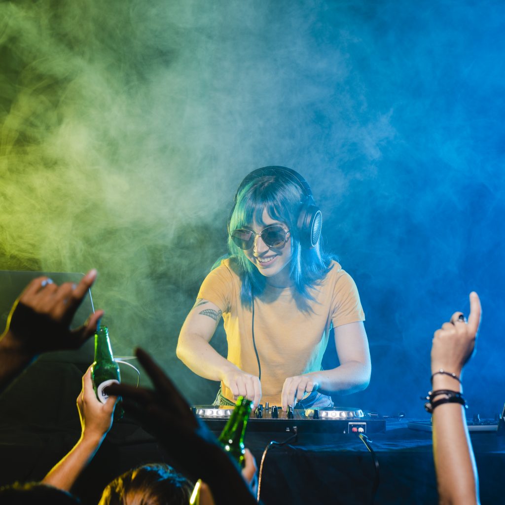 DJ en live set devant un public en fête, entourée d’effets lumineux colorés – illustration d’un clip ou d’un contenu musical monté dans le cadre des services de montage vidéo à Lorient proposés par Keltic Prod